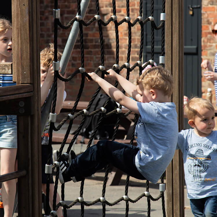 Children having fun playing on the climbing frame in the toddler playground
