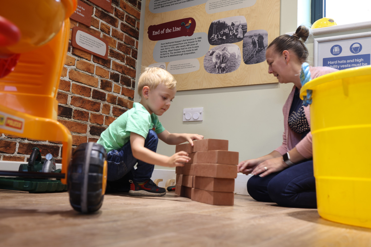 Photo of a child and grown up playing in the construction zone of the Imaginary Play Town
