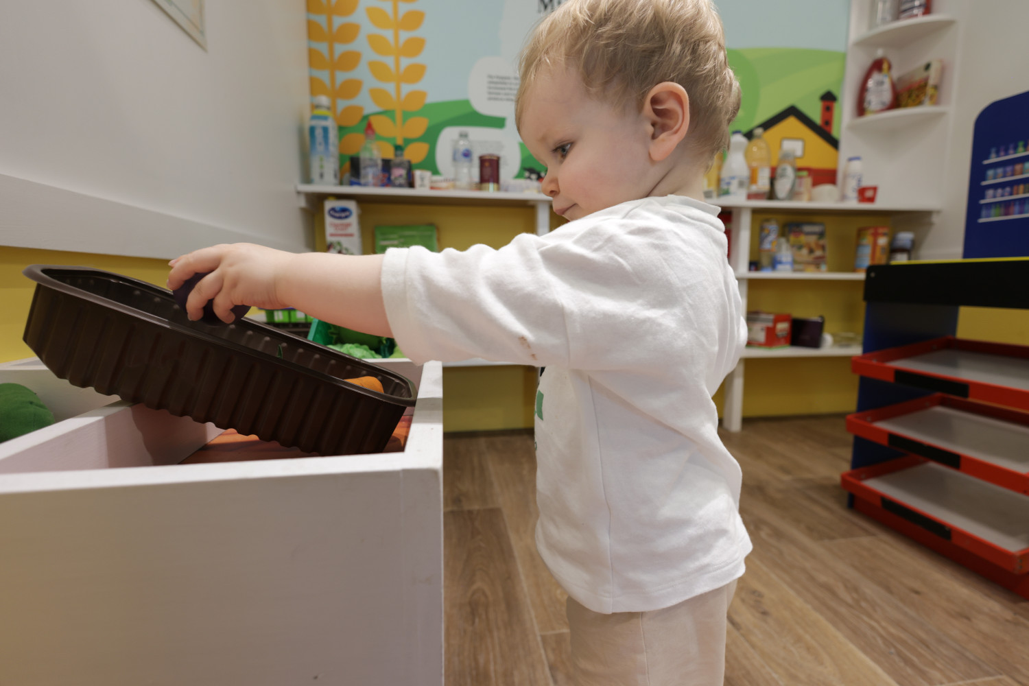 A photo of a child playing in the shop in the Imaginary Play Town